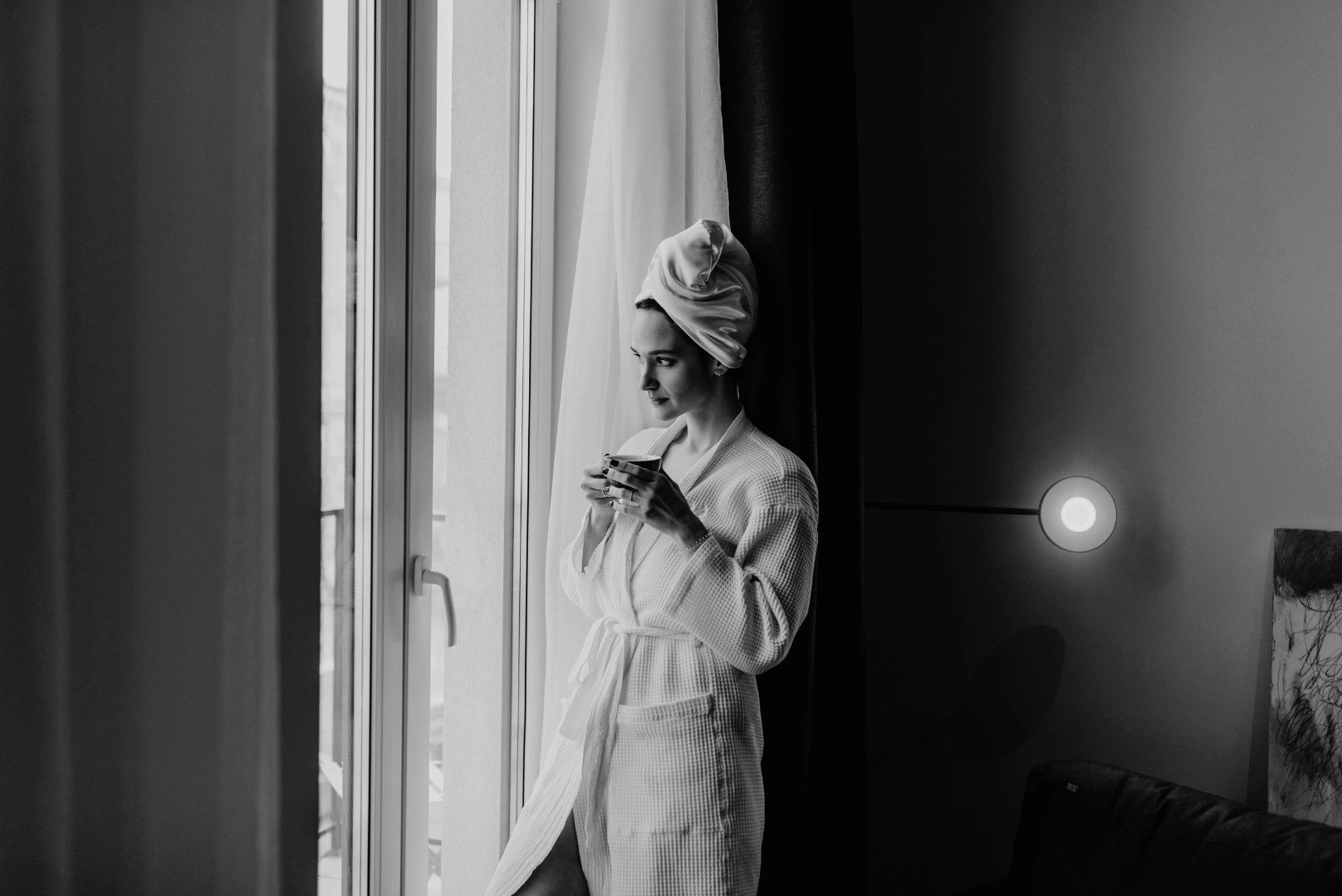 Femme qui regarde à la fenêtre de la chambre à l’hôtel 3 étoiles à Lucciana